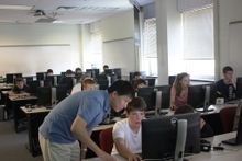 Instructor helping students at computers from the 2013 Summer Camp